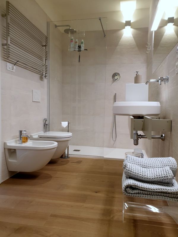 Bathroom with walk-in shower, wall-hung toilet and bidet, and washbasin