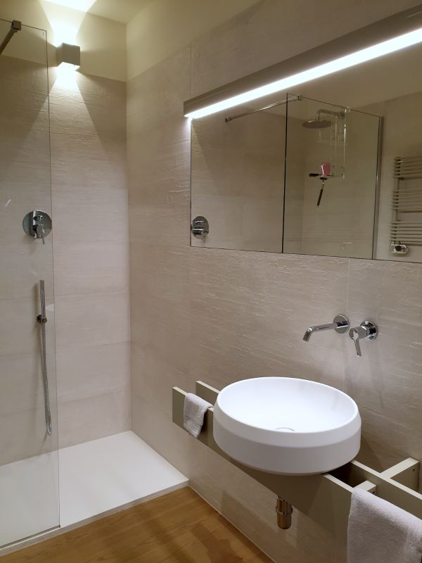 Bowl washbasin and large lit mirror in the bathroom